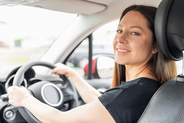 Fototapeta na wymiar Beautiful young woman driving a car. Attractive brunette in the car.