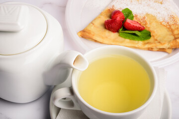 Breakfast with green tea and strawberry pancake. 