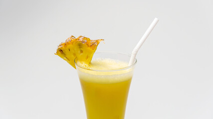Pineapple Juice in a glass with a piece of pineapple
