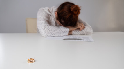Widow mourns the death of her husband. Caucasian woman signs divorce papers and cries