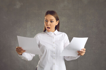 Woman gets letters with astonishing news. Office worker, employee, businesswoman looking at paper...