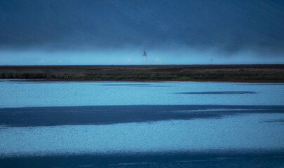 Shore of calm sea in foggy evening