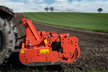 Agrarmotive - Ackerbau. Traktor und angehängter Kreiselegge auf einem Acker im Frühjahr. Acker...