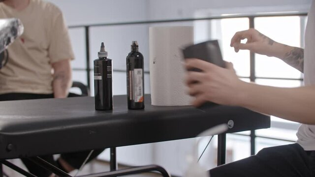 Man with tattoo preparing vaseline and tattoo ink 