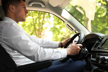 Handsome man driving his modern luxury car