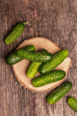 Crispy cucumbers on a wooden stand, marble background