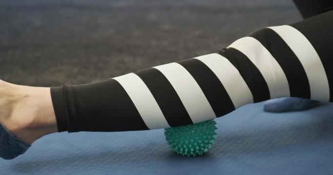 Calf fascia massage with ball for MFR. Roller to roll out calf muscles. Myofascial release.