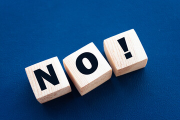 Wooden cubes with text no on a blue background. Negative answer concept. No risk, no violence or no...