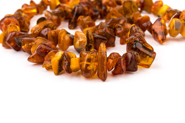Baltic necklace made of Natural polished transparent honey luxury amber beads with inclusions on white. close up selective soft focus. Space for text