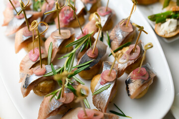 view of pieces herring in vinegar served with onions and decorated by rosemary