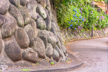 Close up on a dry stone retaining wall construction along the curvy slope of the Asuka-no-komichi...