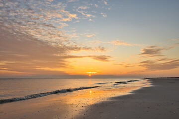 Horizontal seascape of a sunset with clouds during ebb. Horizon over the water with copy space.