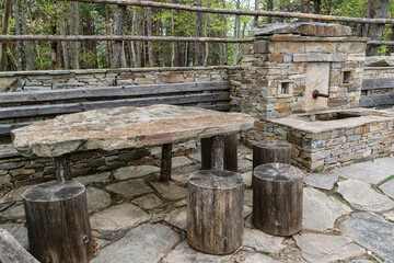 A place for rest during hiking, a table from a stone plate, and chairs from wooden stumps.