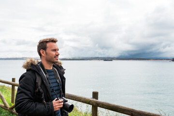 Fototapeta premium attractive Man photographing sea against overcast sky