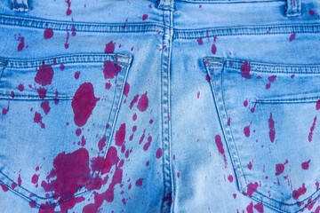drops of red paint on blue  jeans