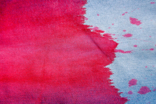 drops of red paint on blue  jeans