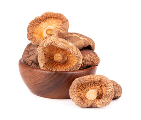 Dried shiitake mushrooms in wooden bowl, isolated on white background. Japanese forest mushroom. Lentinula edodes. Close up.