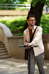 Happy smiling man with electric scooter. Handsome man enjoyung in the nature..