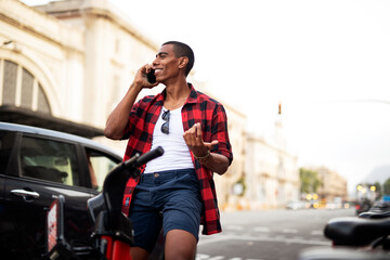 Fototapeta premium Portrait of handsome afro man using electric bike in the city. Happy young man riding bicycle in the city.