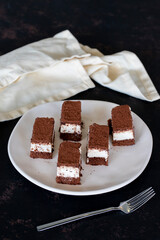 Small tiramisu cake on dark background