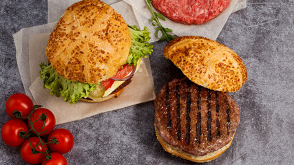 Tasty grilled home made burgers with beef, tomato, cheese, cucumber and lettuce. Top view. Flat lay