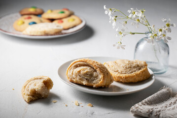 White saucer with fresh cookies and flowers on the morning table