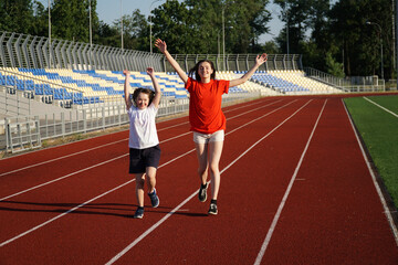 Little girl running on the stadium with a coach - 441593612