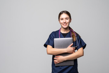 Beautiful Caucasian woman doctor or nurse holding a laptop computer isolated on a white background