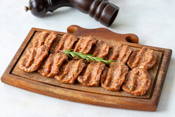 Spicy raw meatballs on wooden background. Turkish meatballs
