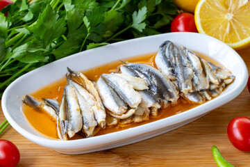 Close-up marinated anchovies on wooden background. Seafood dishes. Anchovy with local name sauce