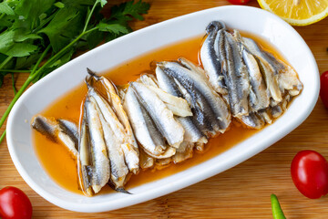 Close-up marinated anchovies on wooden background. Seafood dishes. Anchovy with local name sauce