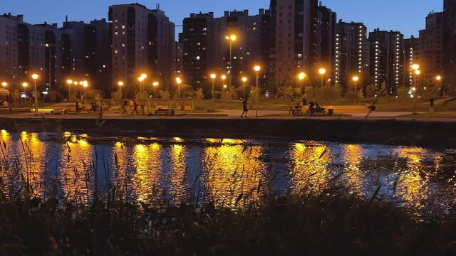 A park against the background of a river in the evening in St. Petersburg. Video in 4K format. Peter at night.