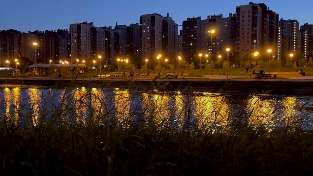 A park against the background of a river in the evening in St. Petersburg. Video in 4K format. Peter at night.