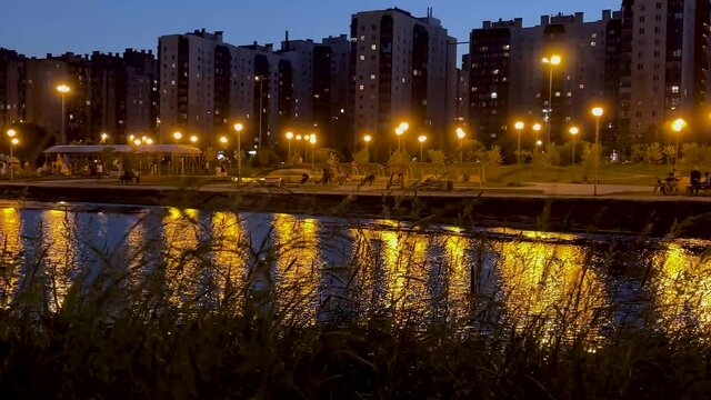 Russia, St. Petersburg, June 15, 2021: A park against the background of a river in the evening in St. Petersburg. Video in 4K format. Peter at night.