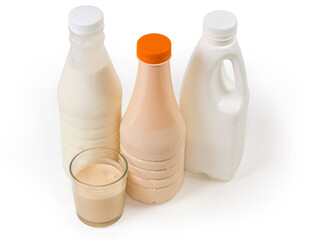 Glass of fermented milk against plastic bottles of dairy products