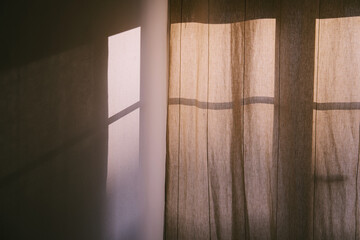 cozy window with curtains in the room. Shadow and sunlight on the wall