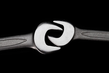 Two steel wrenches isolated on black background closeup. Concept of love, relationship, valentines...