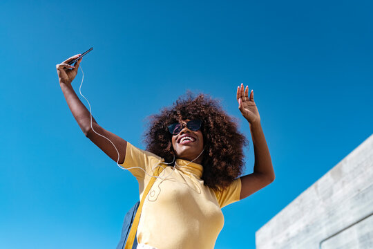 Happy black woman taking self portrait on smartphone outdoors
