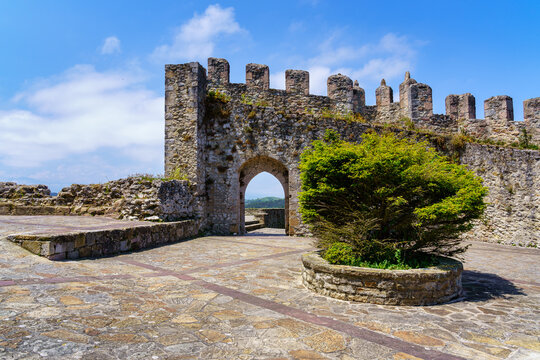 Medieval castle with stone wall and arched entrance gate in sunny day. Suances Santander.