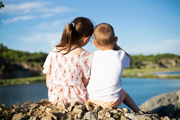 girl and boy sit next to each other with their heads bowed