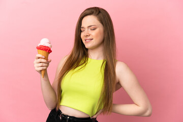 Teenager girl with a cornet ice cream over isolated pink background suffering from backache for having made an effort