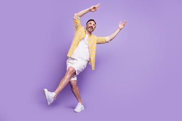 Fototapeta premium Photo of funky sweet mature man dressed striped shirt spectacles walking dancing empty space smiling isolated violet color background