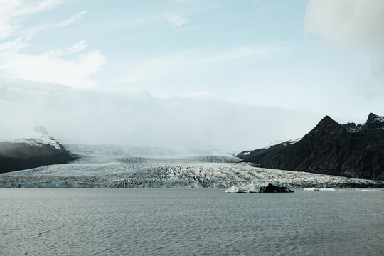 Iceberg between mountains near water