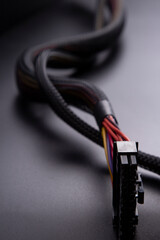 Black connector and Cable with snake skin. Black braided wires in bundle on black background. Data...
