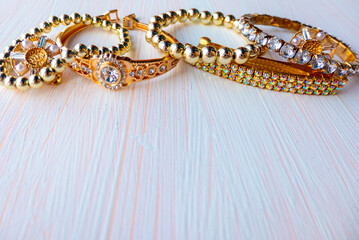 a lot of gold costume jewelry with different materials on a white background. Copy space