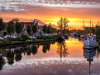 Wijddraai canal with boats at sunset, city of IJlst, Friesland, Netherlands