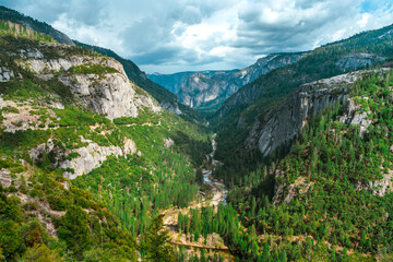 Fototapeta na wymiar A winding river flowing in the mountains, photographed from above in Yosemite National Park, California.