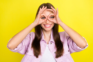 Portrait of attractive cheerful girl showing ok-sign like glasses having fun isolated over bright yellow color background