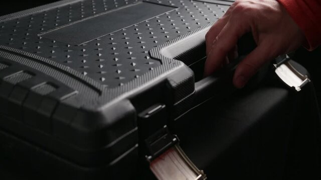 worker man in red clothes open and taking tool wrench spanner socket from black toolkit