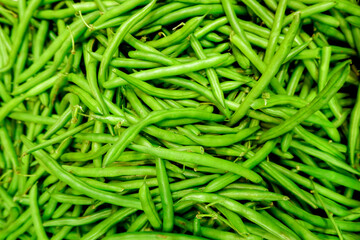 Fresh green beans piled on the market. Food background. Harvest